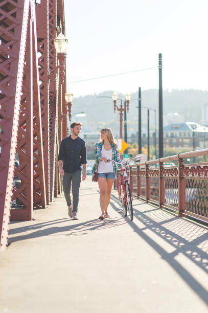 istock Millennial couple walking across a city bridge together 966482496