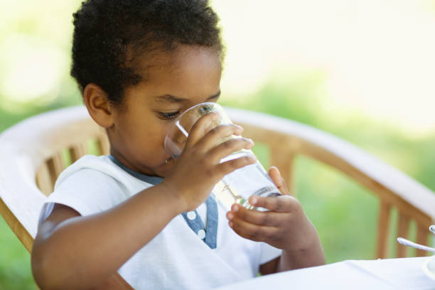 istock Toddler boy drinking a glass of water 966483194