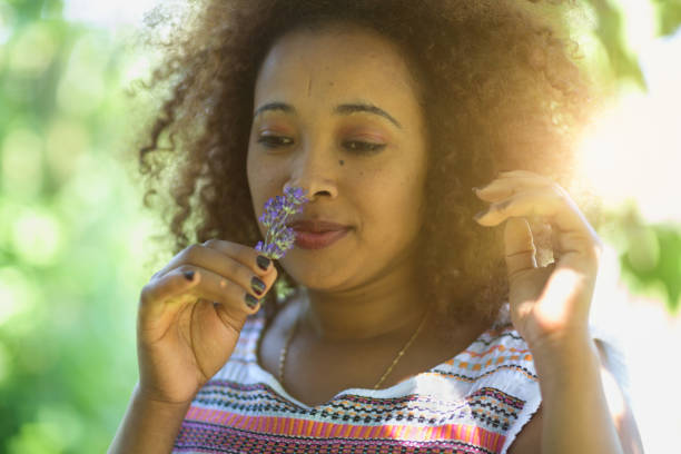 istock african woman smelling lavender flower 966486076