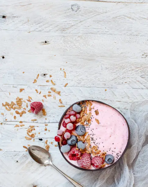 Wild berries smoothie bowl topped with frozen berries and granola
