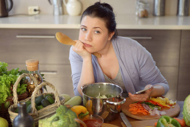 istock woman cooking in the kitchen ( with smartphone) 966489678