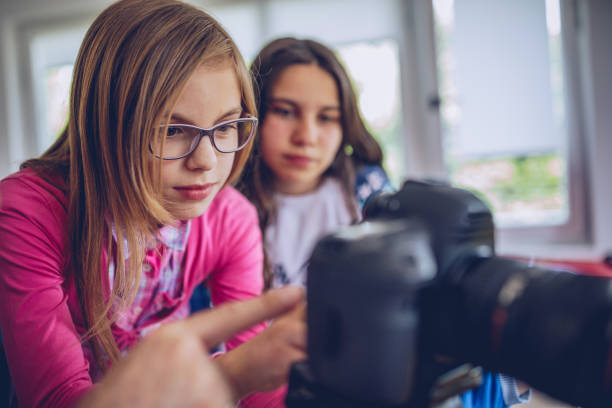 istock Girl teaching how to use digital camera 966492508