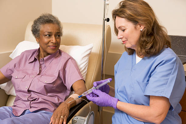 медсестра дает пациент инъекции - chemotherapy drug стоковые фото и изображения