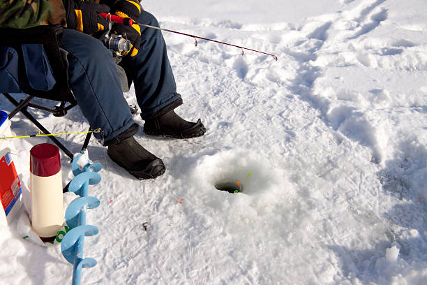 Ice fisherman waiting for a catch Fishing for trout through ice ice fishing stock pictures, royalty-free photos & images