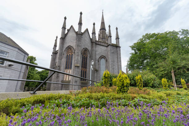 fiori viola e la chiesa di san nicola che si univano - scotland town square war memorial photography foto e immagini stock