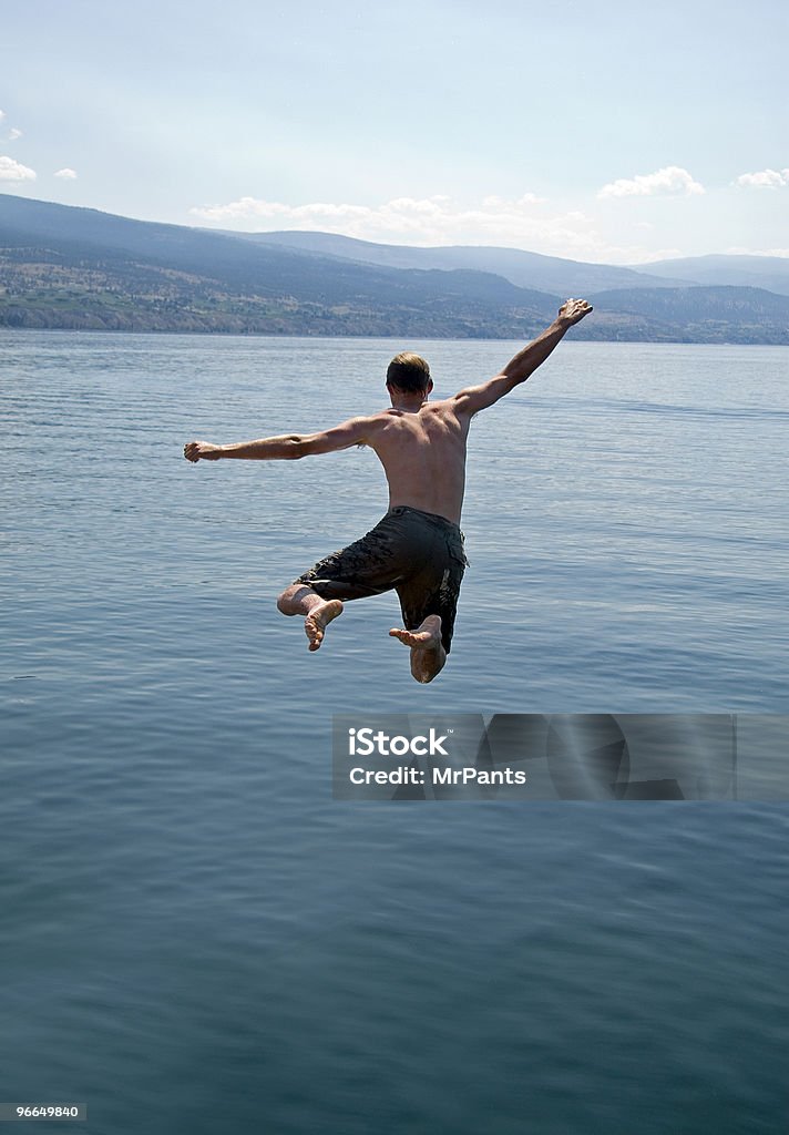 Airborne młody człowiek Skoki do jeziora - Zbiór zdjęć royalty-free (Taking the Plunge - powiedzenie angielskie)