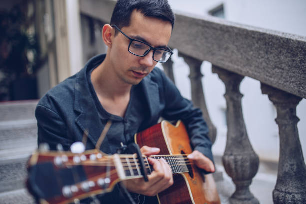 istock Young man with a disability playing acoustic guitar 966498496