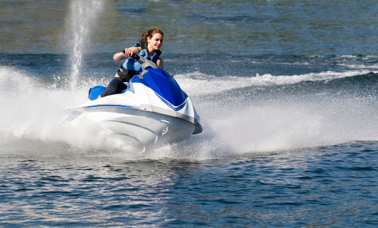 A young woman sits in meditative focus, using her last moments aboard the speedboat to prepare for the thrill of skydiving