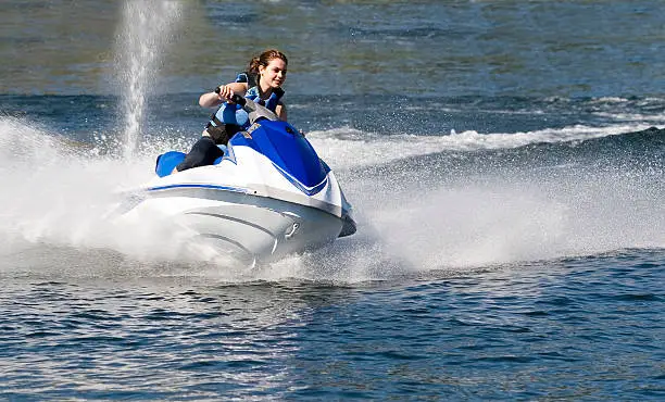 DSLR action photo of young woman on seadoo, including multi-directional water spray