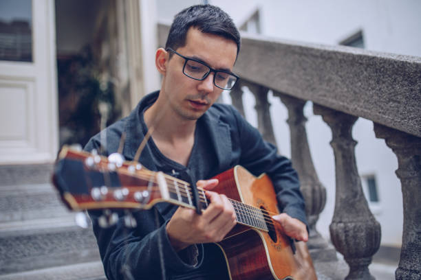 istock Man with differing abilities playing acoustic guitar outdoors 966498634