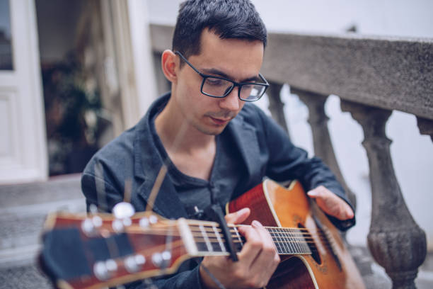 istock Man with a disability playing acoustic guitar 966499542