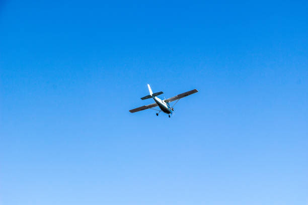istock Small plane flies against a blue sky background close-up 966503308