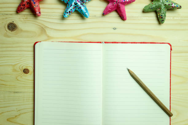 istock Open Book with A Pen on a Wooden Table 966506460