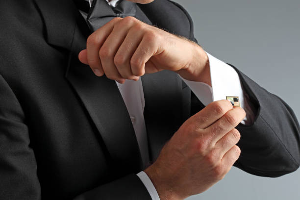 istock Man In Tuxedo Putting On His Cuff Links 966507244