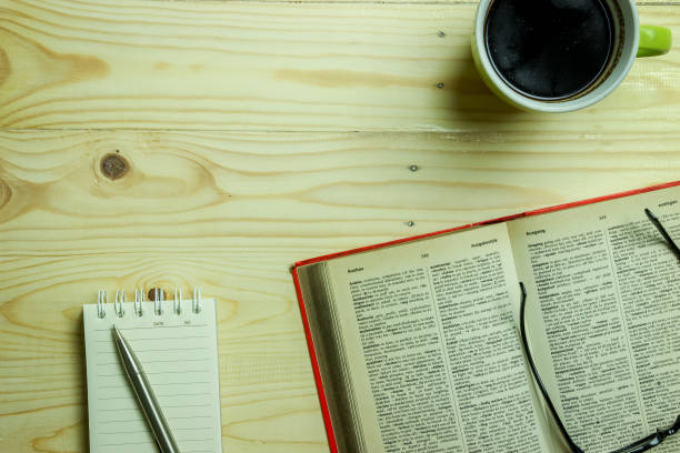 istock Work Table Setting Background with An Open Book and a Cup of Coffee 966507906