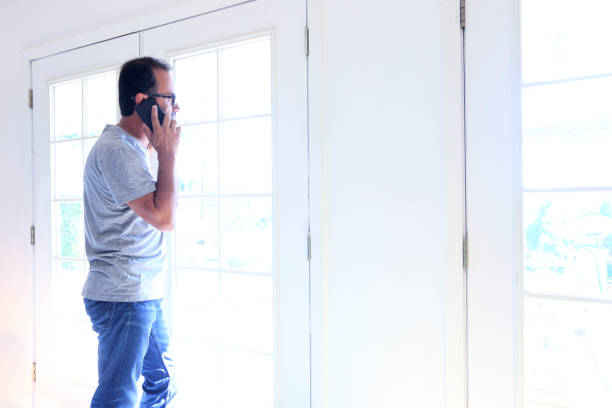 istock Hispanic Man Talking On Cell Phone At Home 966509752