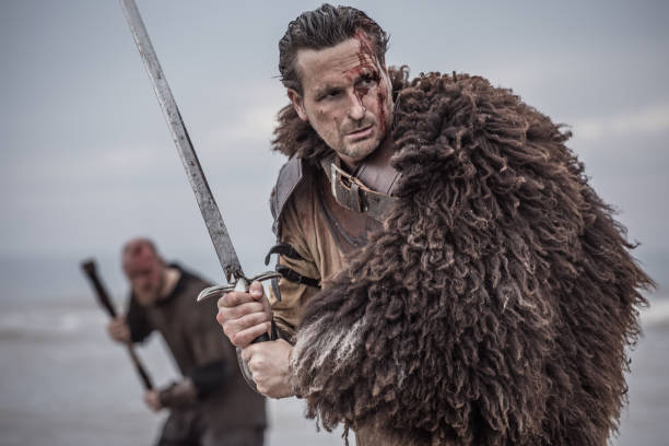 istock Two sword wielding bloody medieval warriors charging together on a cold seashore 966513170