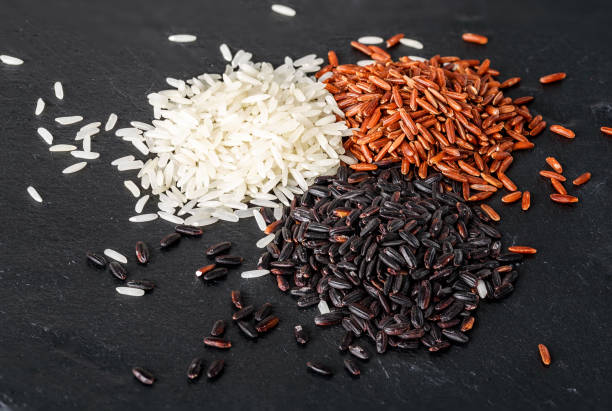 istock Jasmine rice, Red rice, Black rice on black stone background 966513276