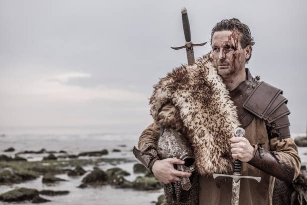istock Weapon wielding bloody medieval warrior alone on a cold seashore 966513346