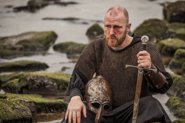 istock Weapon wielding bloody bald redhead bearded medieval warrior alone on a cold seashore 966513600