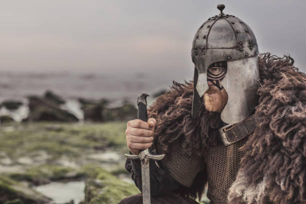 broń dzierżąca krwawego średniowiecznego wojownika samotnie na zimnym brzegu morza - wiking zdjęcia i obrazy z banku zdjęć