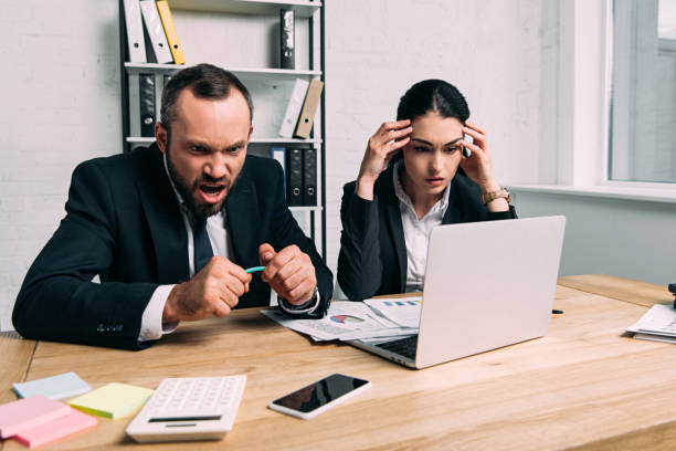 istock stressed and overworked business people at workplace with documents and laptop in office 966524538