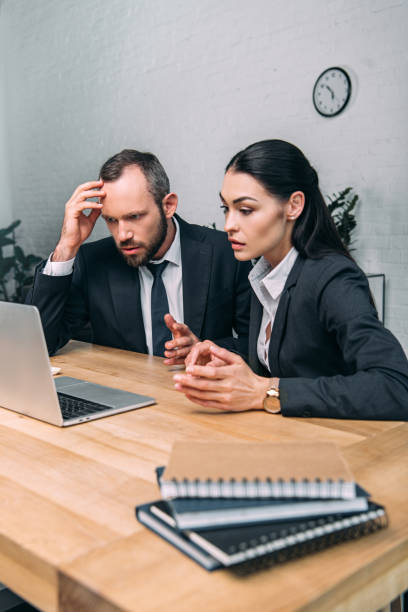 istock overworked business people working on laptop together at workplace in office 966530284