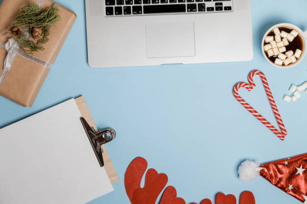 istock New Year Resolution 2018, hot cocoa with marshmallows, gifts, packing paper, scissors on a blue table. top view 966533082