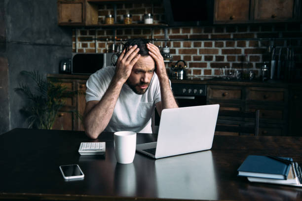istock portrait of overworked freelancer remote working at table with laptop in kitchen at home 966536706