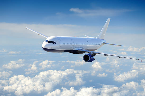 istock White airplane flying above billowy clouds 96653918
