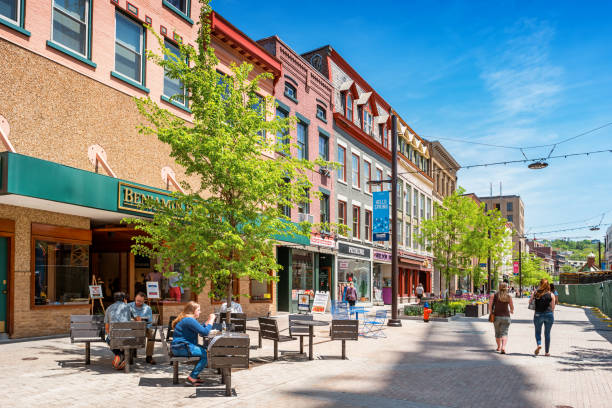 Downtown Ithaca New York State USA People have lunch and walk in a pedestrian area of downtown Ithaca, New York State, USA on a sunny day. ithaca stock pictures, royalty-free photos & images