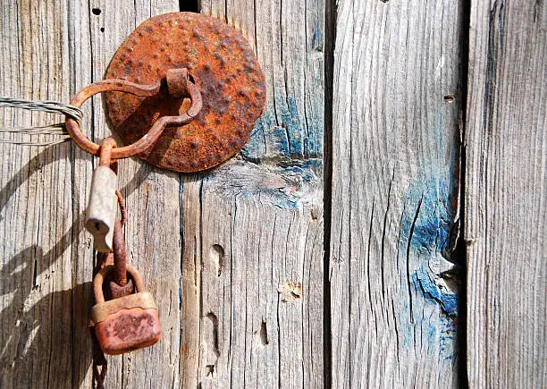 Photo of Old rusty wooden door with padlock