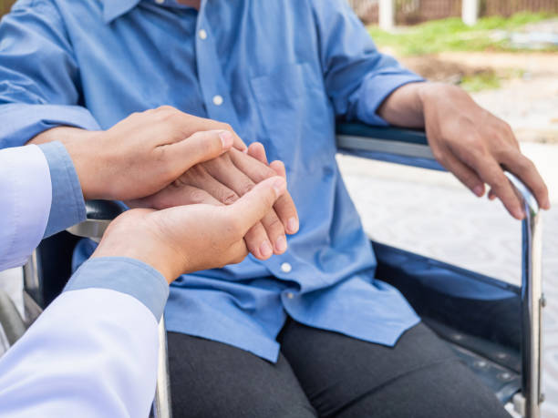 istock Doctor hold hand patient on wheelchair. 966549178
