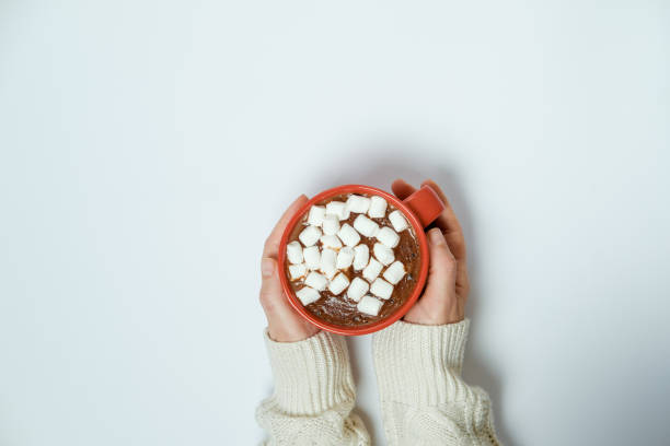 istock Woman hands with cocoa with marshmallow on white background 966552216