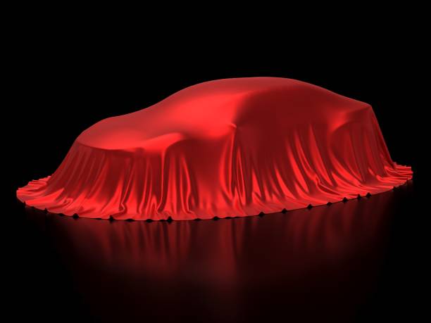 istock New car presentation, model reveal, hidden under red cover, isolated on black background 966554798