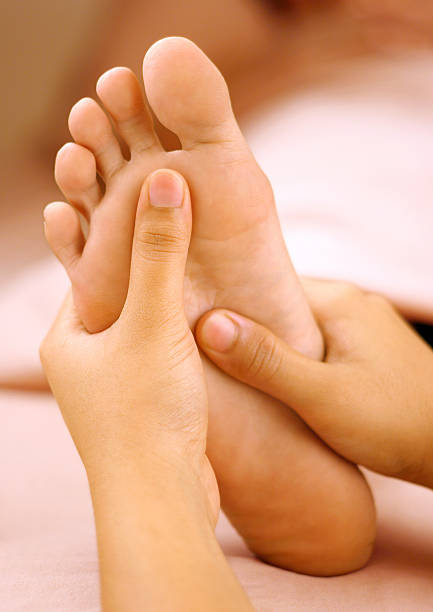 spa massaggio ai piedi - reflexology human foot physical therapy massaging foto e immagini stock