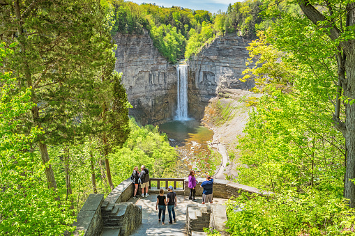 People look at Taughannock Falls near Ithaca, Finger Lakes region, upstate New York, USA on a sunny day.