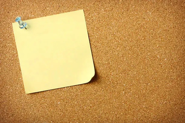 Photo of Blank yellow note on cork message board