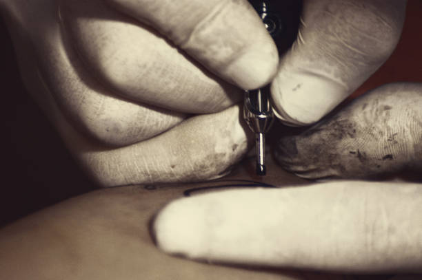 Young woman getting tatoo on her leg