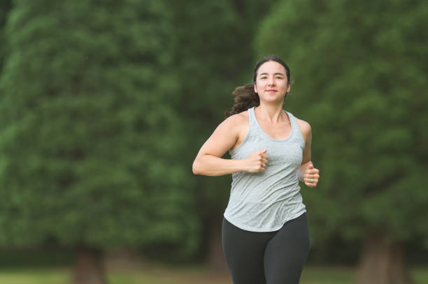 istock Solo female in her 30s jogs through the park 966564418