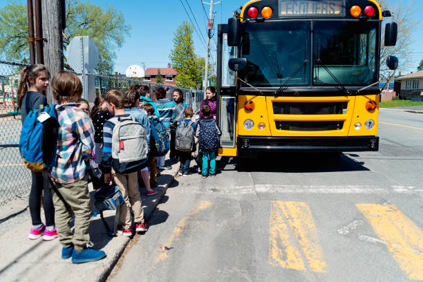 istock Kids in line waiting to get on school bus. 966572836