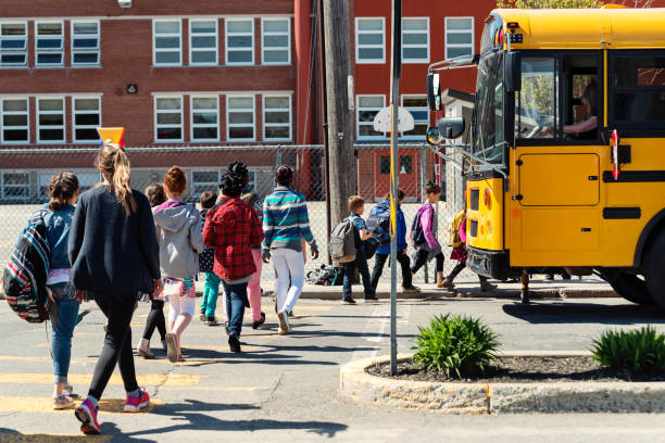 crianças na rua de passagem de linha para entrar no ônibus da escola. - autocarro escolar - fotografias e filmes do acervo