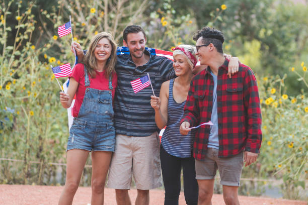 istock A group of multiethnic, multigenerational friends hold up American flags 966611444
