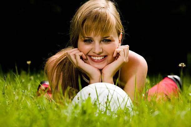 Lovely woman lying on a grass stock photo