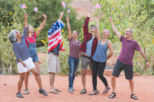 istock A group of multiethnic, multigenerational friends hold up American flags 966611738
