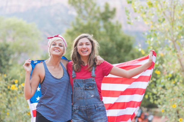 istock Two friends drape themselves in an American flag outside 966612278
