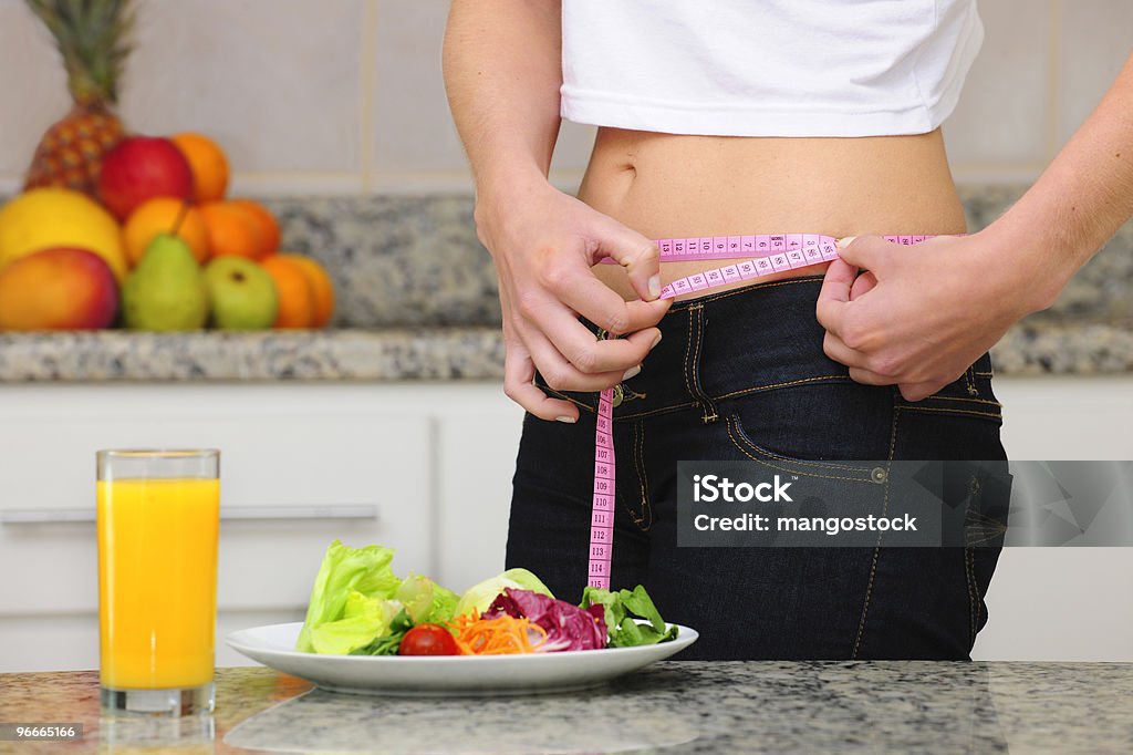 diet: woman with salad and measuring tape  Adult Stock Photo