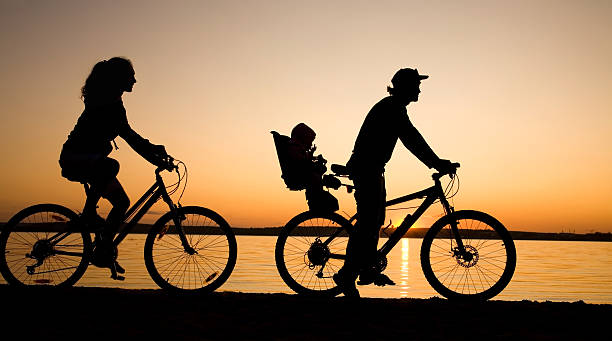 família bicycler - silhouette three people beach horizon - fotografias e filmes do acervo