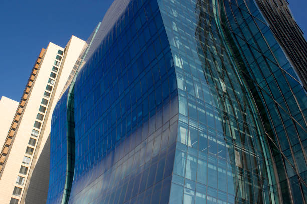istock Modern curved blue corporate building next to a yellowish classical one. 966686834