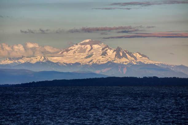istock snow mountain at a cloudy sunset with sea water in the foreground 966687202